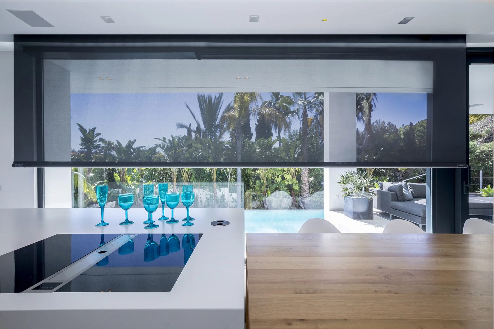 Estor enrollable screen oscuro en cocina con vista tropical