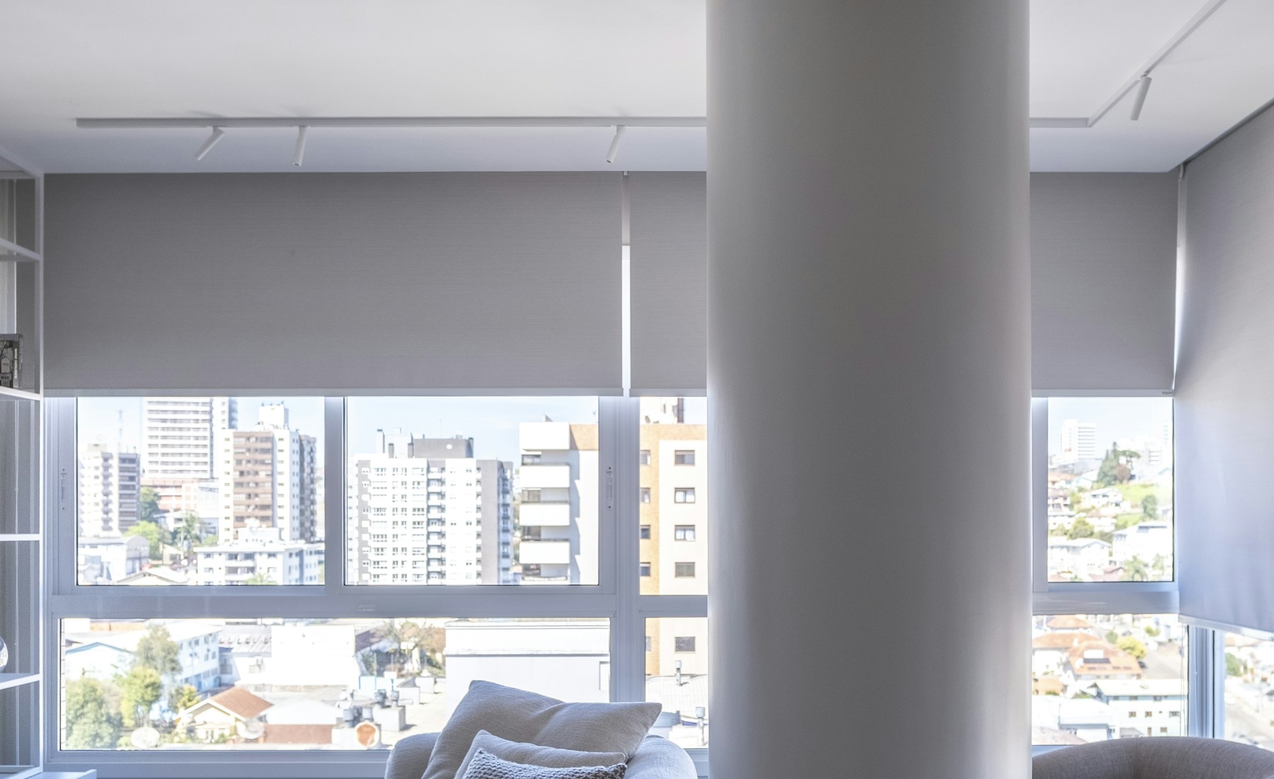 Salón moderno con grandes ventanales y estores de interior