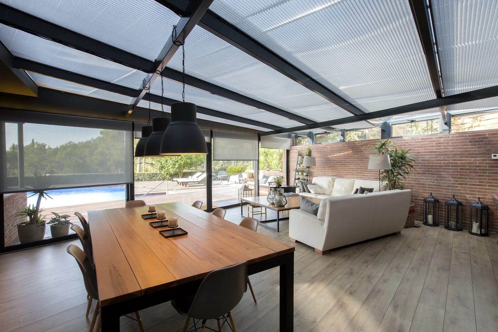 Plisados en porche cubierto con pergola acristalada y jardín