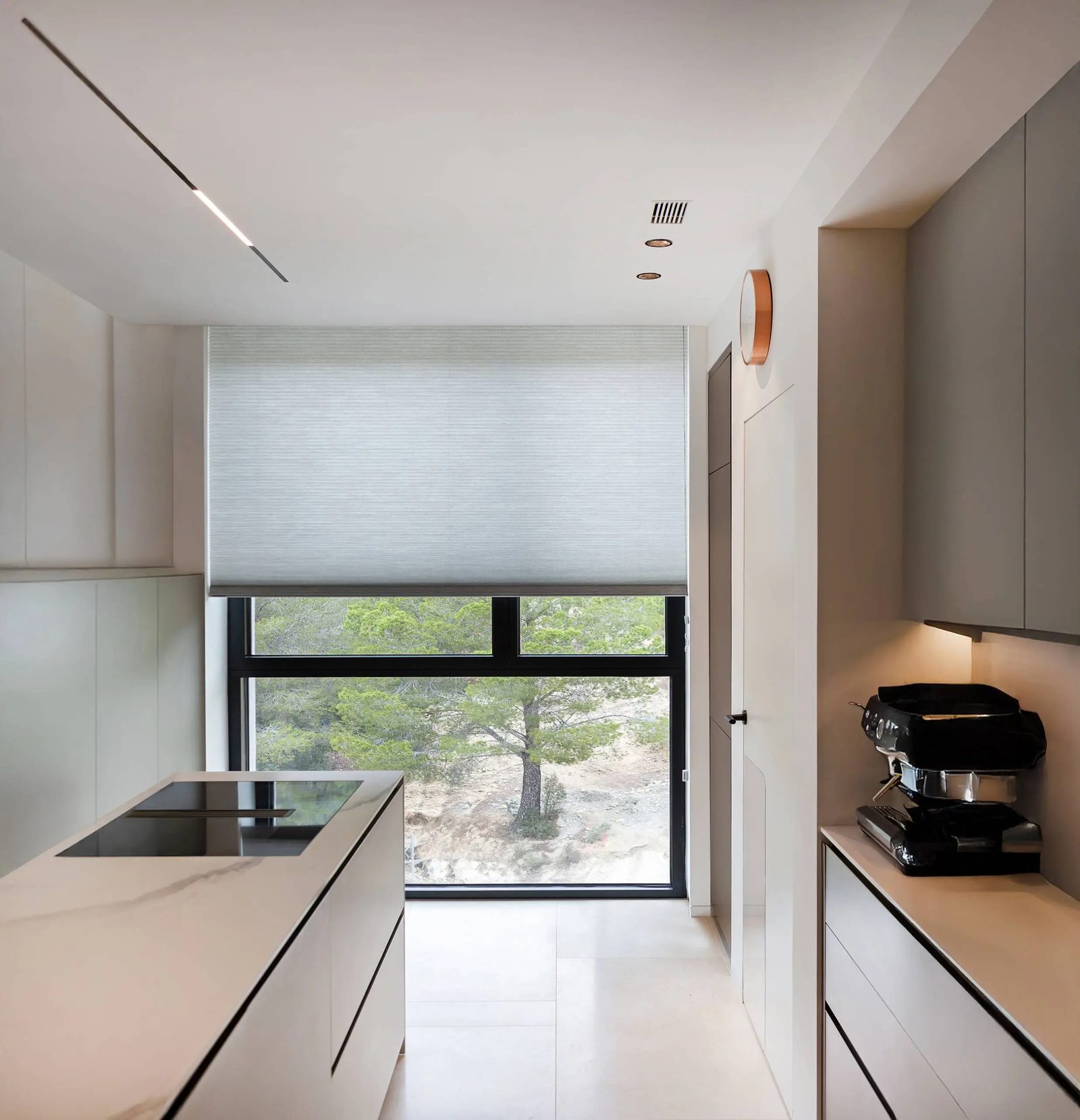 Plisado blanco en cocina moderna con ventana al jardín